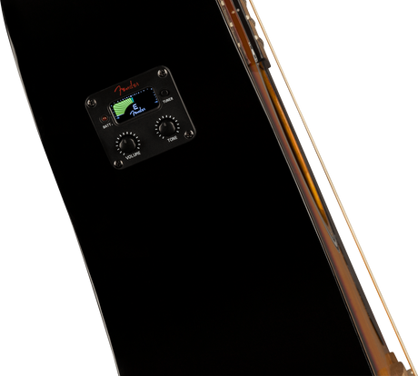 The image shows a close-up of a Fender acoustic guitar preamp/EQ system installed in a black guitar body. It features a digital tuner displaying the note "C" with Fender branding, two control knobs labeled "VOLUME" and "TONE," and a battery indicator light. Part of the guitar’s wooden edge is visible. This built-in system allows for amplification and convenient tuning during live or recording sessions.