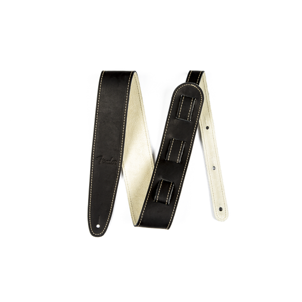 The image shows a black leather guitar strap with cream-colored lining and decorative contrast stitching. It features an adjustable length mechanism, padded construction for comfort, reinforced ends with attachment holes, and a visible brand logo. This classic, professional strap provides shoulder support for standing guitar players and has a versatile, timeless black and cream design.
