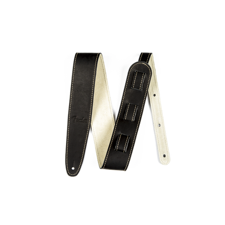 The image shows a black leather guitar strap with cream-colored lining and decorative contrast stitching. It features an adjustable length mechanism, padded construction for comfort, reinforced ends with attachment holes, and a visible brand logo. This classic, professional strap provides shoulder support for standing guitar players and has a versatile, timeless black and cream design.