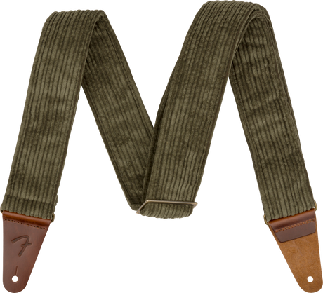 The image shows a guitar strap made of olive green corduroy fabric with ribbed texture and brown leather end tabs. It features an adjustable slider mechanism and a "Fender" logo embossed on one leather end. Designed for comfort and durability, the strap securely attaches to guitars, making it suitable for both acoustic and electric instruments.