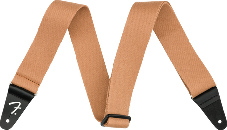 The image shows a tan/brown woven cotton or canvas guitar strap with black leather Fender-branded end tabs. It has an adjustable length and a classic, functional design. This essential accessory helps guitarists and bassists comfortably play while standing by distributing the instrument’s weight across the shoulder and torso, suitable for various musical styles and performance settings.