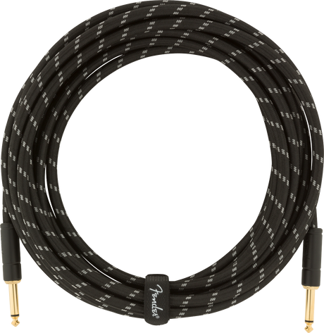 The image shows a professional Fender instrument cable with a black braided exterior featuring white/gray accents. It has gold-plated 1/4" TS connectors on both ends and is coiled, indicating a length of 15-20 feet. The cable includes visible Fender branding and is designed to reduce interference and ensure reliable signal transmission for electric guitars, basses, and other electronic instruments.