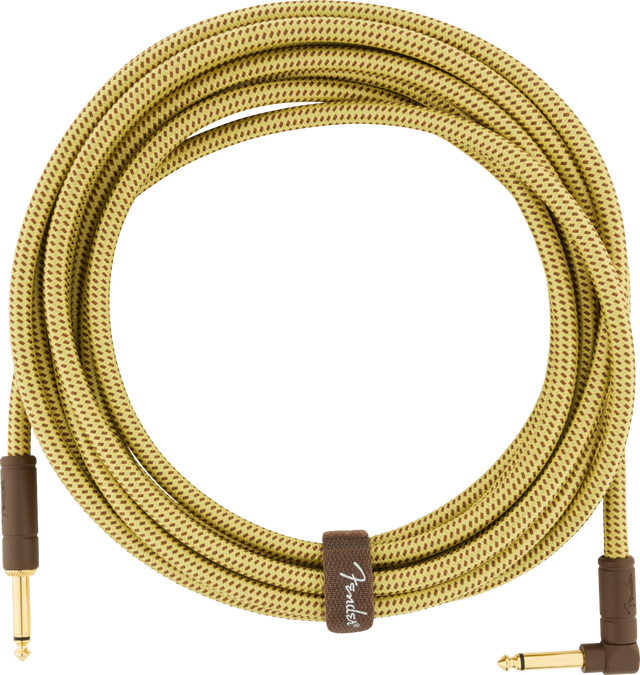 The image shows a Fender guitar cable with a yellow/tan tweed woven fabric covering featuring a diamond pattern. It has gold-plated 1/4" connectors: one straight and one right-angle plug. A brown fabric band with the Fender logo wraps the coiled cable. Designed for electric instruments, the vintage-style sheath offers durability, reduced tangling, and a classic look, while the right-angle plug minimizes strain on guitar input jacks.