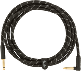 The image shows a coiled musical instrument cable with a black braided exterior featuring a white zigzag pattern. It has gold-plated 1/4" TS connectors—one straight and one right-angle. A cable tie with the "Fender" logo secures it. Designed for electric guitars, basses, and other instruments, the durable braided jacket and gold connectors ensure reliable performance and corrosion resistance.