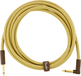 The image shows a Fender instrument cable with a yellow/gold woven tweed jacket and gold-plated 1/4" TS connectors—one straight and one right-angle. It includes a brown leather-like Fender-logo cable tie. Designed for electric guitars, basses, and other instruments, this vintage-style, shielded cable ensures high-quality signal transmission while minimizing noise, combining professional-grade build with classic aesthetics.