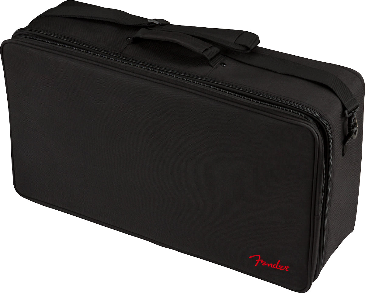 The image shows a black Fender gig bag, a rectangular, padded soft case made of durable fabric with zippered compartments and reinforced handles. It features the red Fender logo on the bottom right. Designed for carrying musical gear like amplifier accessories or pedals, it has a professional, utilitarian style typical of Fender’s musician equipment cases.