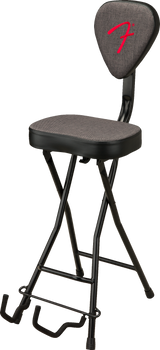 The image shows a foldable, height-adjustable musician’s stool with a padded gray seat and backrest featuring a red Fender logo. It has a black metal X-style frame and a built-in guitar stand at the base for resting instruments. Designed for guitarists and other musicians, this ergonomic stool combines comfort and practicality in an official Fender-branded accessory.