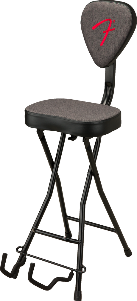 The image shows a foldable, height-adjustable musician’s stool with a padded gray seat and backrest featuring a red Fender logo. It has a black metal X-style frame and a built-in guitar stand at the base for resting instruments. Designed for guitarists and other musicians, this ergonomic stool combines comfort and practicality in an official Fender-branded accessory.