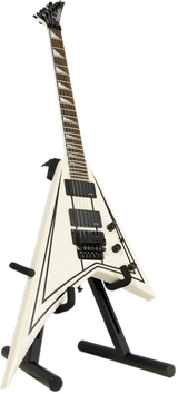 The image shows a white/cream Flying V electric guitar with black pickguards, hardware, and trim. It has a dark neck and headstock, multiple humbucker pickups, and a Floyd Rose-style tremolo bridge. The angular V-shaped body is supported by a black stand. This iconic design is popular in rock and metal genres, favored for its distinctive look and tremolo system that enables pitch bending effects.