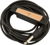 The image shows an acoustic guitar soundhole pickup with a wooden top featuring a curved design, housed in a black mounting frame with visible screws. A long black cable with a 1/4" instrument jack extends from the pickup. This device converts string vibrations into electrical signals, allowing acoustic guitars to be amplified while maintaining a natural wood aesthetic.