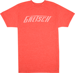 The image shows a coral/orange-red t-shirt with "GRETSCH" printed in white across the chest. This shirt is branded merchandise from Gretsch, a renowned musical instrument company known for guitars, drums, and other instruments since 1883. Gretsch is especially famous for its hollow-body electric guitars favored by many iconic musicians.