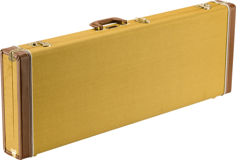 The image shows a classic electric guitar hard case with a golden-yellow tweed exterior, brown leather-like trim, and brass-colored metal hardware. It has a brown leather handle and a rectangular, elongated shape typical of electric guitar cases. The vintage-style tweed covering and reinforced corners provide both a retro aesthetic and sturdy protection for guitars during transport and storage.