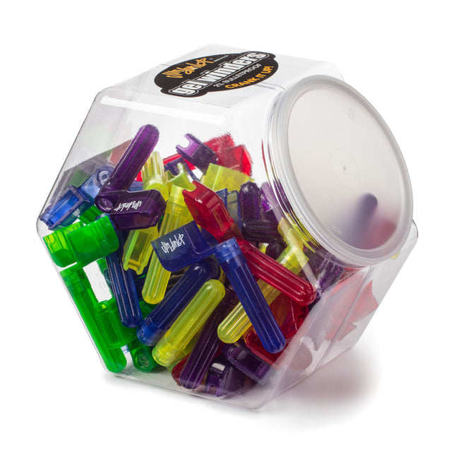 A plastic jar filled with different color guitar pegwinders on a white backround