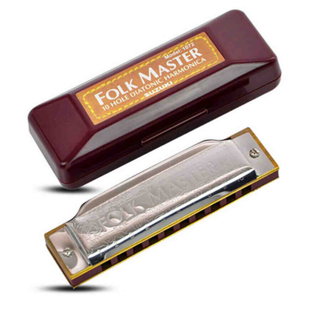 The image shows a Suzuki "Folk Master" model 1002 10-hole diatonic harmonica with a chrome cover plate, decorative engraving, and a brass-colored comb. The harmonica rests beside its burgundy protective case, labeled with the model and brand. This common folk and blues instrument’s case helps protect its delicate reeds when not in use.