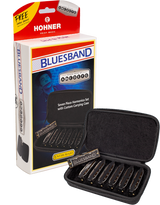 The image shows a Hohner Bluesband harmonica set featuring seven harmonicas in keys A through G, designed for intermediate players. The set includes a red and white branded box with a "FREE Online Warp!" offer and a black zippered case. Each harmonica is labeled "BLUESBAND," offering a complete blues-focused set for playing in multiple keys.