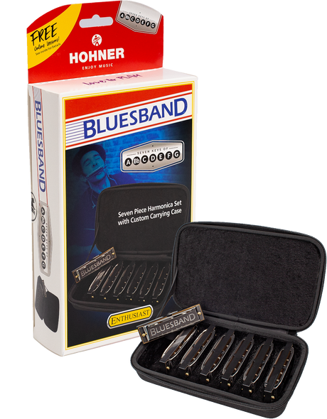 The image shows a Hohner Bluesband harmonica set featuring seven harmonicas in keys A through G, designed for intermediate players. The set includes a red and white branded box with a "FREE Online Warp!" offer and a black zippered case. Each harmonica is labeled "BLUESBAND," offering a complete blues-focused set for playing in multiple keys.