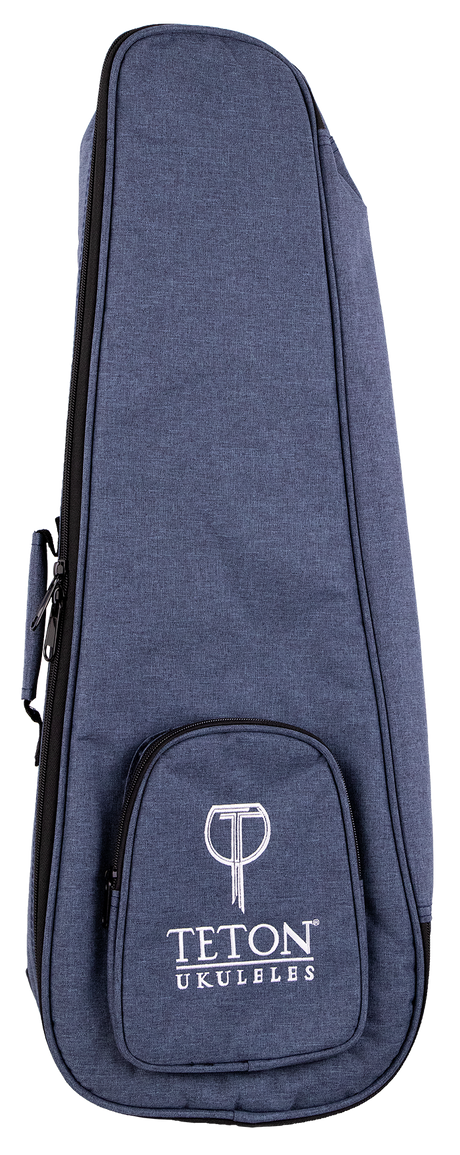 The image shows a Teton Music ukulele gig bag made of blue denim-textured fabric with a zippered edge and a small front pocket featuring the "TETON UKULELES" logo in white. Designed for concert or tenor ukuleles, this padded, soft-sided case offers lightweight protection during transport. It includes carrying handles and likely shoulder straps, making it a practical accessory for musicians on the go.