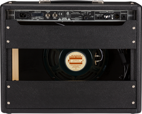 The image shows the back panel of a guitar amplifier with the rear cover removed, revealing a Jensen Special Design speaker. The panel features control knobs, input/output jacks, XLR connections, power specs, and a voltage selector. The amp has black tolex covering, metal corners, a handle, ventilation grilles, and professional-grade construction, indicating it’s suited for live or studio use.