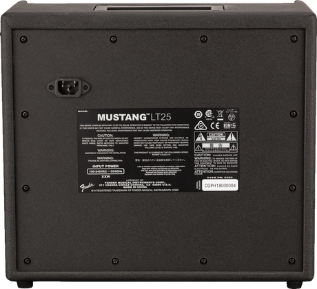The image shows the back panel of a Fender Mustang LT25 guitar amplifier. It features a Fender logo and model label, a 25-watt power rating, an IEC power inlet, a specifications panel with technical details and safety warnings, the serial number in the bottom right, and ventilation screws around the edges. The panel lists input power (100-240V AC, 50/60Hz), certifications, and manufacturing info.
