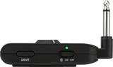 The image shows a compact black wireless audio transmitter for musical instruments. It features a 1/4" instrument jack, "SAVE" and "ON/OFF" buttons with a Bluetooth symbol, a green LED power indicator, and a clip for attaching to clothing or straps. The device enables cable-free play by transmitting audio wirelessly, offering musicians freedom of movement and reducing stage hazards.