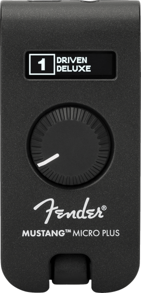 The image shows a Fender Mustang Micro Plus, a compact black guitar headphone amplifier with a textured finish. It features a digital display reading "1 DRIVEN DELUXE," a large rotary knob, the Fender logo, and the model name. The device plugs directly into an electric guitar for silent practice, offering amp simulations and effects in a portable design.