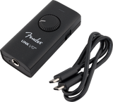 The image shows a matte black Fender Link I/O audio interface, a compact digital device for music recording. It features a large volume knob, a 3.5mm headphone jack, and a USB-C connection for computers or mobile devices. Designed for portability, it enables musicians to record instruments, monitor audio with low latency, and convert analog signals to digital, ideal for guitarists and home studios.