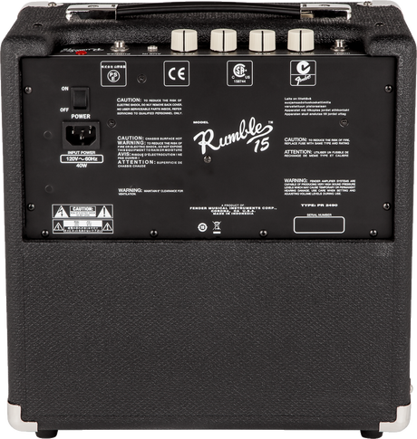 The image shows the back panel of a Fender Rumble 15 bass amplifier, a compact 15W practice amp. Visible features include the Fender Rumble branding, power switch, IEC power input, carry handle, four cream-colored control knobs, safety labels, model PR 2490, and serial number area. The black textured cabinet has corner protectors, reflecting Fender’s durable design ideal for home practice and small gigs.
