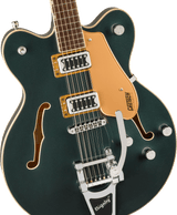The image shows a beautiful Gretsch hollow-body electric guitar with a deep green finish and cream binding. It features f-holes, an orange pickguard with the "GRETSCH" logo, two gold-ringed humbucking pickups, a Bigsby vibrato tailpiece, four control knobs, a rosewood fingerboard with dot inlays, and chrome hardware. This high-end model blends classic Gretsch style with versatile tones ideal for rockabilly, jazz, and indie rock.