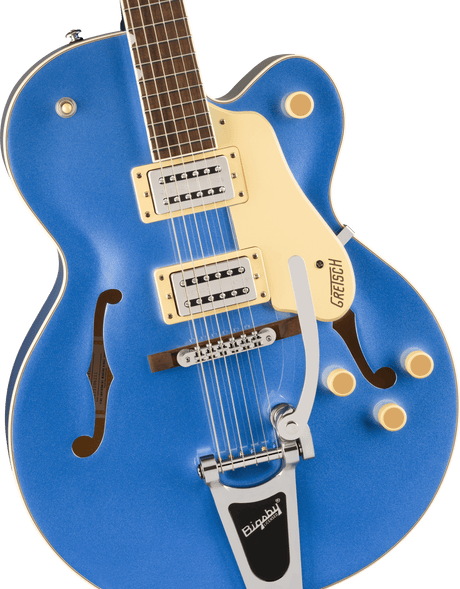 The image shows a beautiful blue hollow-body Gretsch electric guitar with a classic single-cutaway archtop design and f-holes. It features cream binding, two humbucking pickups with cream rings, chrome hardware, a Bigsby vibrato tailpiece, multiple control knobs, and an adjustable bridge. The dark rosewood fretboard has pearl block inlays. This iconic guitar is favored in jazz, rockabilly, and rock genres for its bright, articulate tone.