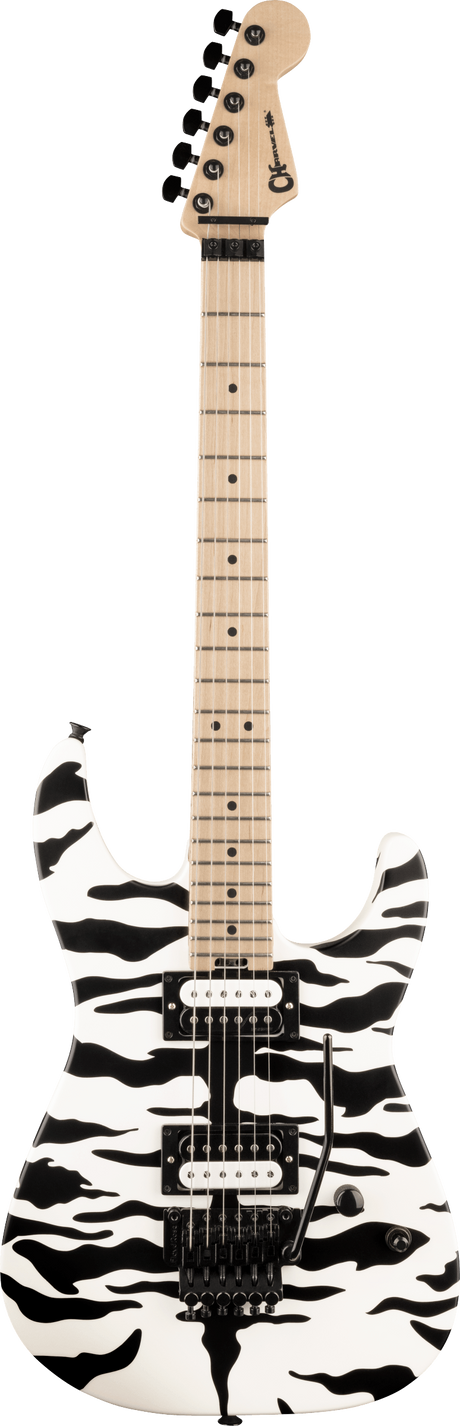 The image shows a Charvel electric guitar with a white body featuring a bold black abstract or camouflage pattern. It has two black humbucker pickups, a black tremolo bridge, black control knobs, and hardware. The neck is light-colored with dot inlays, and the headstock has black tuning pegs. This modern guitar is designed for rock or metal styles, combining visual impact with versatile hardware for expressive playing.