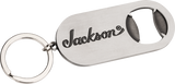 The image shows a metal keychain bottle opener branded with the Jackson logo, a well-known electric guitar manufacturer popular in rock and metal music. This promotional merchandise item highlights Jackson’s identity within the guitar industry, where they produce accessories alongside their high-performance guitars like the Soloist, Dinky, and Rhoads models.