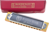 The image shows a M. Hohner Marine Band harmonica (model No. 364) with a silver top plate, brass comb, and decorative portrait medallion. Beside it is its red leather carrying case with gold embossed "MARINE BAND No. 364" text, "MADE BY M. HOHNER" marking, and snap closure. This vintage-style harmonica is iconic for its wooden comb and warm tone, popular in blues, folk, and country music.