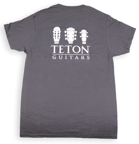 The image shows a dark gray t-shirt with "TETON GUITARS" branding. It features three white guitar headstock silhouettes—a classical guitar, an acoustic steel-string guitar, and a smaller instrument like a ukulele or mandolin—above the text. This minimalist design promotes Teton Guitars, a guitar manufacturer, and serves as branded merchandise for musicians and guitar enthusiasts.