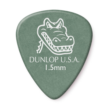 A green 'Dunlop' branded guitar pick with 'gator' artwork on a white background