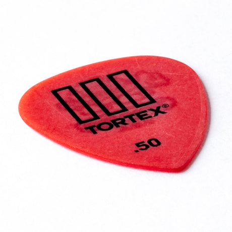 Red guitar pick with 'Tortex' branding on a white background