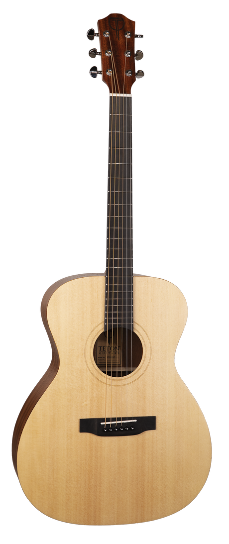 The image shows an acoustic guitar with a natural light wood top, darker wood headstock, and six tuning pegs in a 3+3 layout. It features a dark fretboard with markers, a round sound hole with rosette, a black bridge with a compensated saddle, and steel strings. The guitar has an "OM" body shape, known for balanced, articulate tones, and is photographed on a white background, likely for retail display.