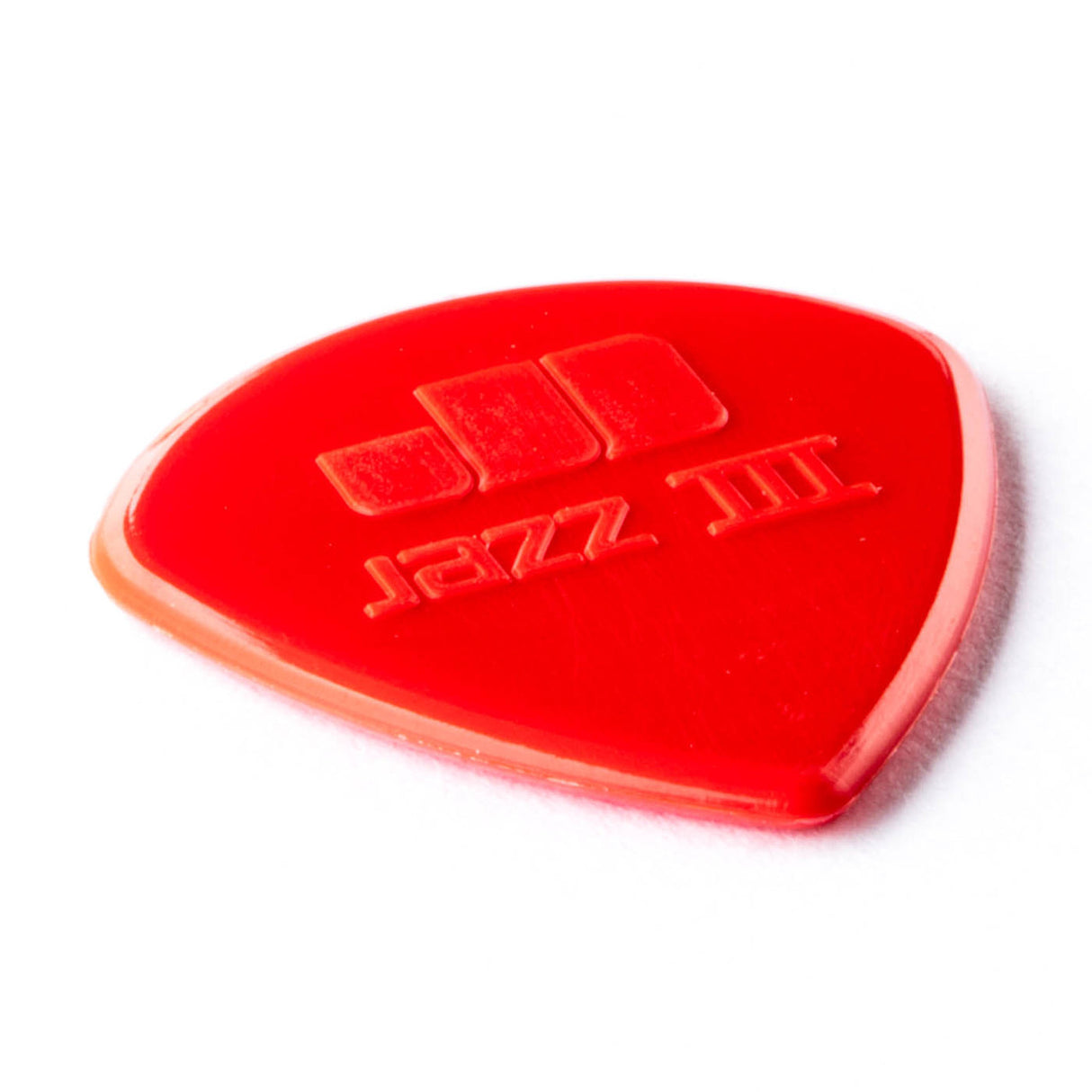 A red guitar pick with Jazz III engraving on a white background