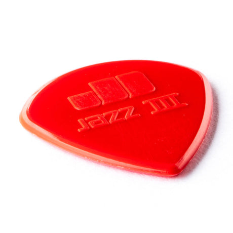 A red guitar pick with Jazz III engraving on a white background