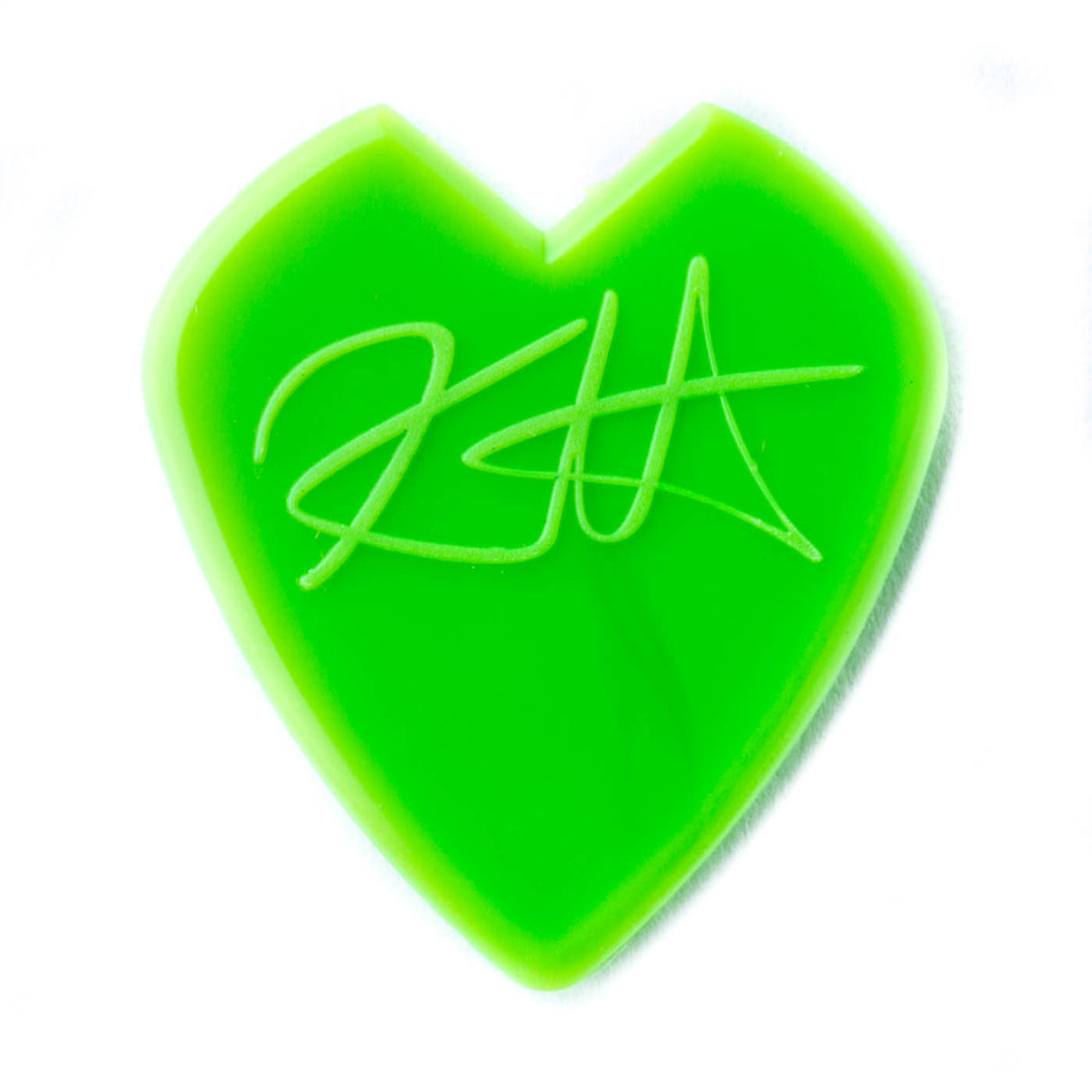 Green heart-shaped guitar pick with a signature on a white background