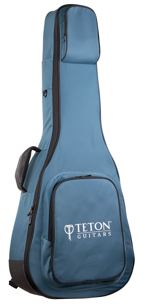 The image shows a blue Teton Guitars padded gig bag for acoustic guitars, featuring black trim, the "TETON GUITARS" logo on the front pocket, multiple compartments for accessories, padded shoulder straps, and a full-length zipper. Made from durable nylon-like material, it offers lightweight, protective transport ideal for Teton and most standard acoustic guitars.