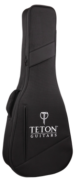 The image shows a black Teton Guitars soft guitar gig bag with a textured fabric surface, white Teton logo and brand name, and a "T" logo at the top. It features diagonal accent stripes, a full-length zipper, and padded shoulder straps. Designed for acoustic guitars, it offers lightweight, portable protection with a sleek, professional look.