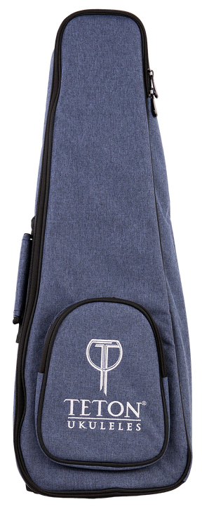 The image shows a blue denim-like ukulele gig bag with the "TETON UKULELES" logo on the front pocket. It features a zippered closure around the perimeter, a front storage pocket, and carrying straps (partially visible). This padded soft case is designed to protect and transport a ukulele, offering a lightweight, protective option. Teton is a well-known brand for acoustic instruments and accessories.