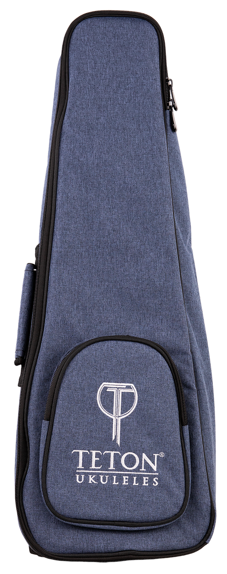 The image shows a blue denim-like ukulele gig bag with the "TETON UKULELES" logo on the front pocket. It features a zippered closure around the perimeter, a front storage pocket, and carrying straps (partially visible). This padded soft case is designed to protect and transport a ukulele, offering a lightweight, protective option. Teton is a well-known brand for acoustic instruments and accessories.