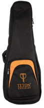 The image shows a TETON ukulele gig bag in black with orange accents. It features padded protection, multiple zippered compartments including a front pocket with the "TETON UKULELES" logo, and side carrying handles. Sized for concert or tenor ukuleles, this soft case offers secure transport and storage for the instrument and accessories like picks and tuners.