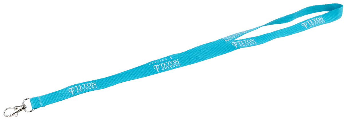 The image shows a bright turquoise Teton Guitars promotional lanyard with white "TETON GUITARS" text repeated along its length. It has a metal clip attachment, commonly used for holding ID badges or keys. This branded accessory is a music industry promotional item likely distributed at trade shows or events to promote Teton Guitars, appealing to guitar enthusiasts and music professionals.