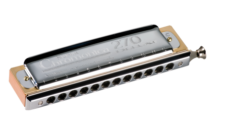 The image shows a Hohner Super Chromonica 270 Deluxe chromatic harmonica with a sleek chrome body and gold end plates. It features a rectangular shape with multiple holes and a slide button on the right side for accessing all 12 chromatic notes. This professional-grade instrument is known for its high-quality construction and is favored by jazz, classical, and blues musicians for its versatility and premium finish.