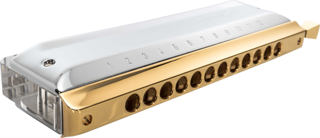 The image shows a chromatic harmonica with a gold-colored metal comb, clear plastic cover plates, and multiple round holes numbered along the top. It features a side-mounted slide button, enabling access to all 12 chromatic notes. This sophisticated instrument is designed for versatility in genres like jazz and classical, indicating it is a high-quality model suited for professional musicians.