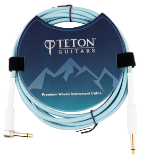 The image shows a Teton Guitars Premium Woven Instrument Cable with a light blue woven exterior for durability. It features gold-plated 1/4" TS connectors—one straight and one right-angle—and includes Velcro ties for organization. The cable is neatly coiled and displayed in professional packaging with Teton Guitars branding, designed for connecting electric guitars or basses to amplifiers or audio gear.