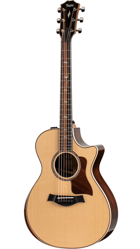 The image shows a high-quality Taylor acoustic guitar with a Grand Auditorium cutaway body. It features a natural spruce top with a glossy finish, dark rosewood back and sides, and a dark wood fretboard with abalone inlays. Chrome tuning pegs, a tortoiseshell pickguard, and acoustic-electric electronics are visible. The guitar has elegant binding, a 6-string steel configuration, and professional-grade craftsmanship typical of Taylor’s higher-end models.