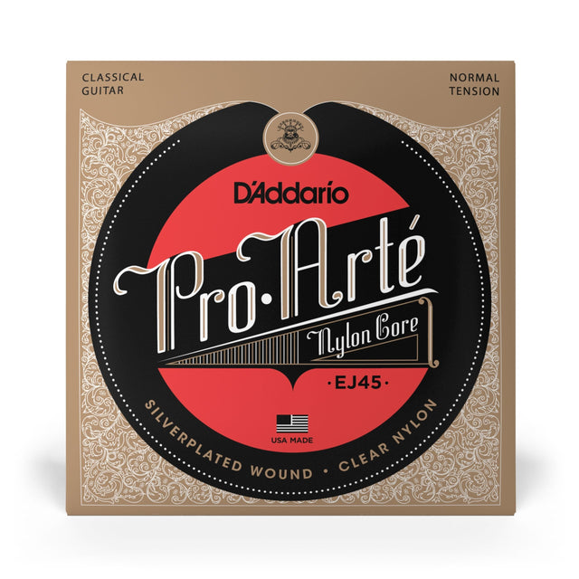 The image shows a package of D'Addario Pro-Arté EJ45 classical guitar strings. It features a vintage-style tan and beige design with ornate borders and a black and red logo. These normal tension strings have a nylon core with silver-plated wound basses, made in the USA. Known for quality and tone, the EJ45 set is popular among classical guitarists.